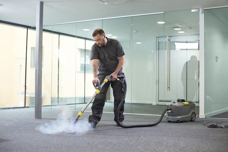 Vamp Building Maintenance technician cleaning carpet via hot water extraction.